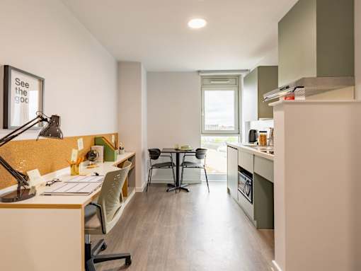 A modern office with a desk, chairs, and a framed poster on the wall.