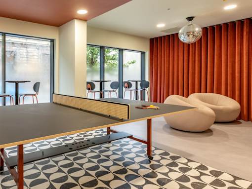 A modern dining room with a long table and chairs.