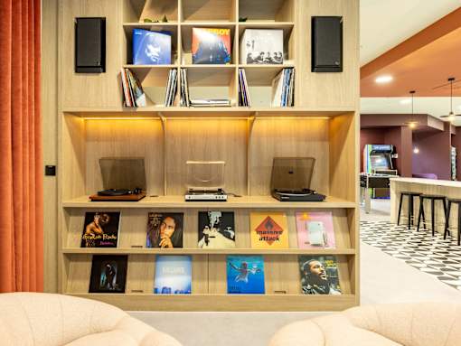 A bookshelf with various books and a laptop on it.