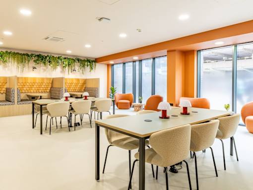 A conference room with white chairs and a long table.