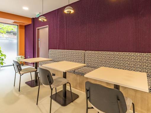 A room with a purple wall and a table with chairs.