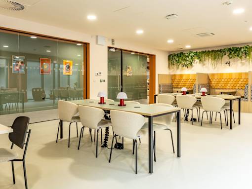 A conference room with white tables and chairs.