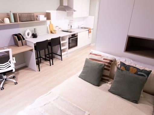 A kitchen with a white countertop and a white chair.