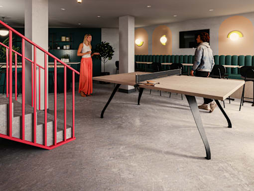 A woman in a red skirt is standing in a room with a red staircase.