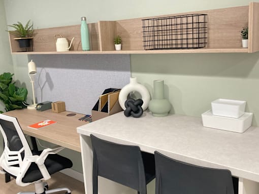 A white desk with a white chair and a white tabletop with a white vase and a white box on it.