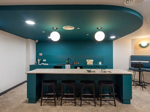 A kitchen with a bar area and stools.