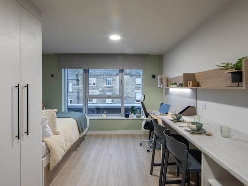 A room with a bed, desk, and chair.