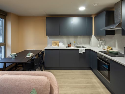 A kitchen with a dining table and chairs.