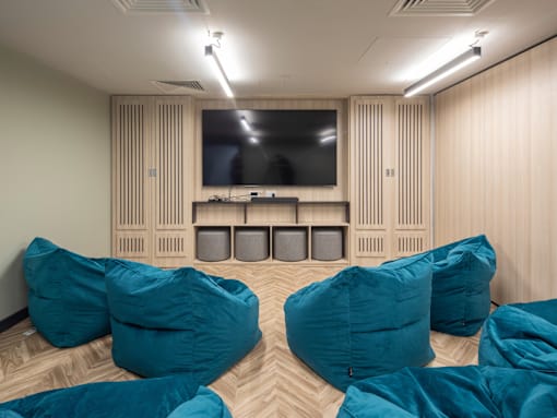 A room with a television and bean bag chairs.