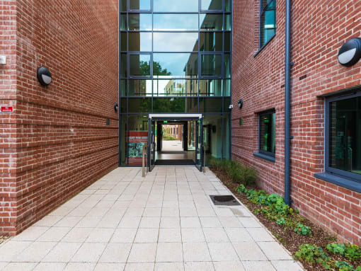 a walkway between two buildings with a large glass window