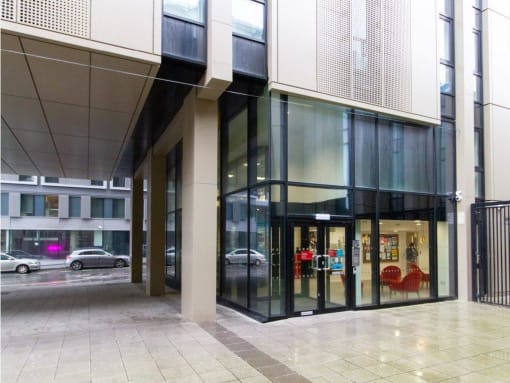 a building with a large glass door and a street in the background
