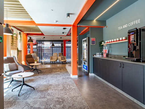 A vending machine and drink station, with nearby seating on the ground floor.