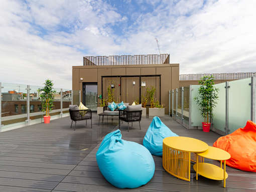 A modern patio with bean bag chairs and a table.