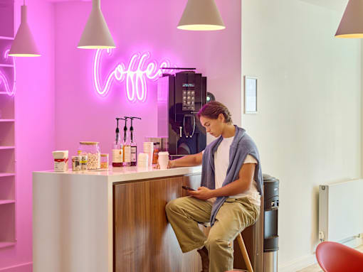A person is sitting on a counter in a coffee shop.