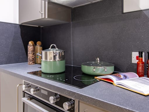 A modern kitchen with a stove top and a pot on it.