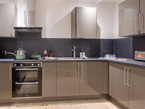 A modern kitchen with a stainless steel oven and wooden cabinets.
