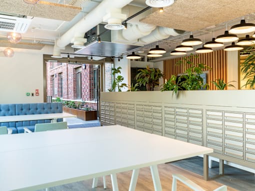 A conference room with a white table and a blue sofa.