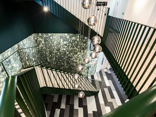 A staircase with a glass railing and a black and white checkered floor.