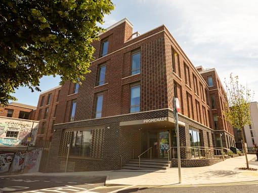 A red brick building with the word "PROMEENADE" on the front.