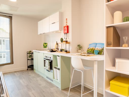 A kitchen with a white table and chairs and a green cabinet.