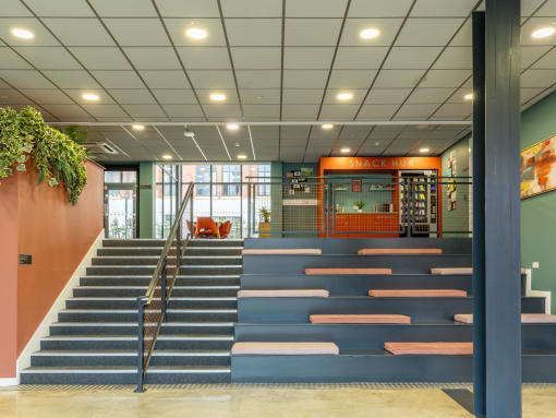 the lobby of a building with blue steps and orange walls