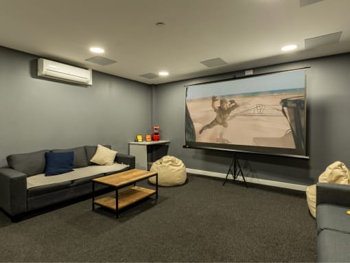 a living room with a projector screen and couches