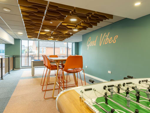 a game room with a foosball table and chairs