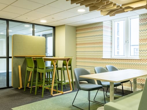a meeting room with tables and chairs and a partition