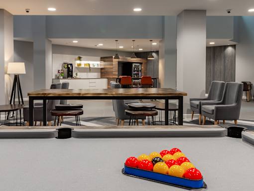 A pool table with a red, yellow, black, and blue ball in the middle.