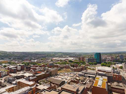 A cityscape with buildings and a cloudy sky.