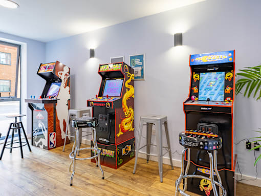 A row of arcade games are lined up in a room.