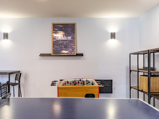 A table with a foosball table in the middle of the room.