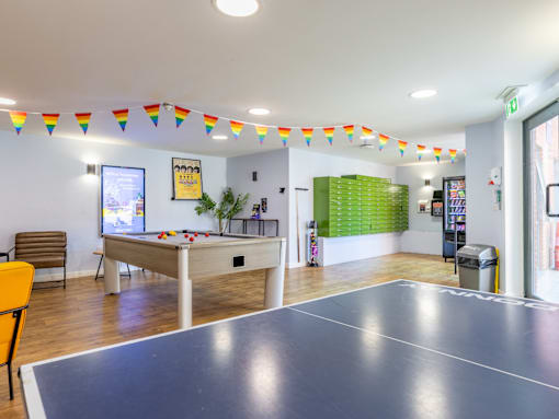 A room with a pool table and a foosball table.