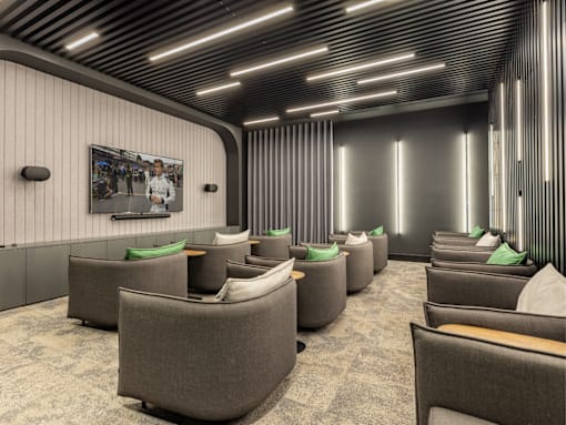 A modern waiting room with grey chairs and a wooden ceiling.