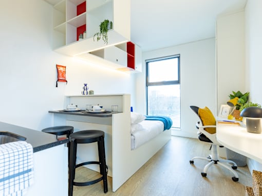 A kitchen with a bar stool and a counter.