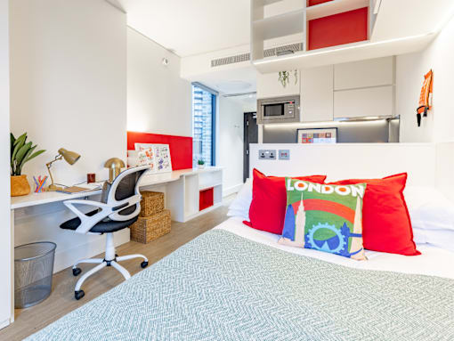 A bedroom with a bed, desk, and chair.