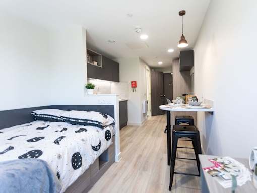 A bedroom with a bed, a table and a chair.