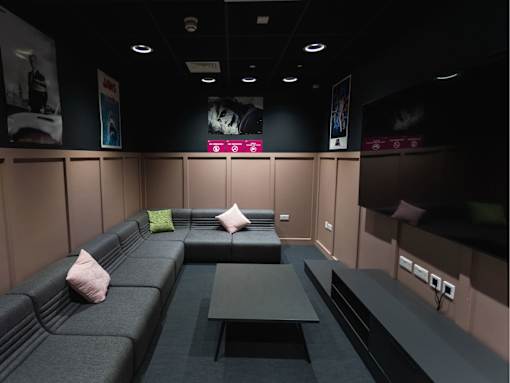 A room with a grey couch and a black table.