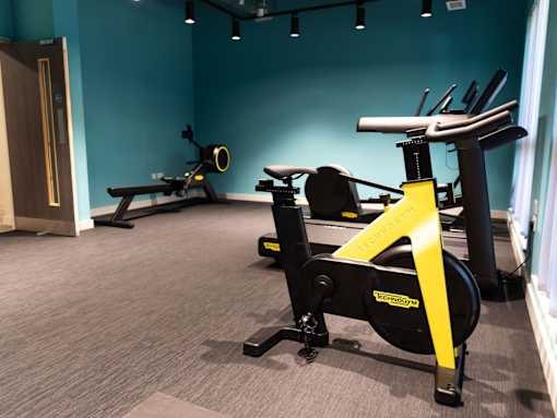 A gym with a row of exercise bikes.