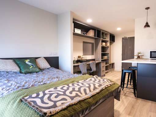 A bedroom with a bed, desk, and chair.