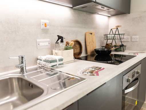 A kitchen with a stainless steel sink and a stove top.