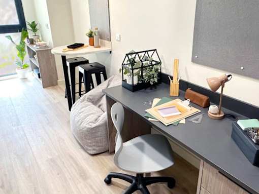 A modern home office with a grey desk, a grey chair, and a grey bean bag.