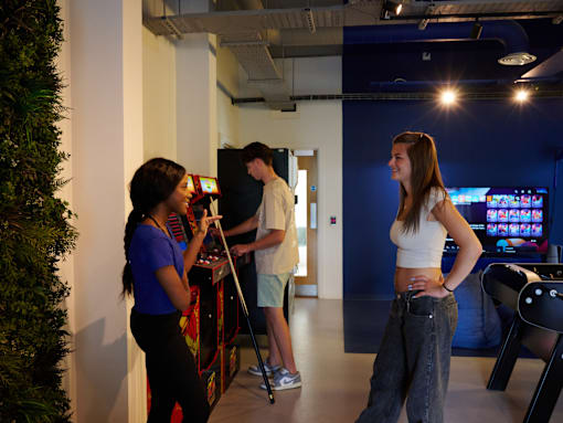 Three people playing a video game in a room.