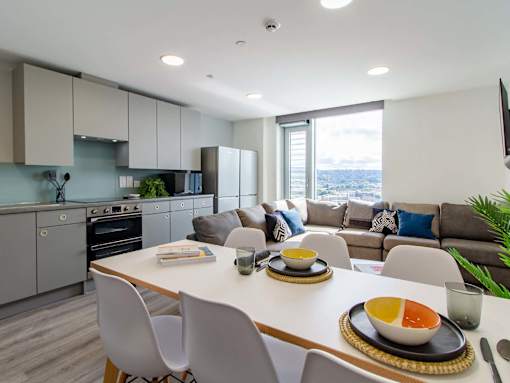 A modern kitchen with a dining table set for two.