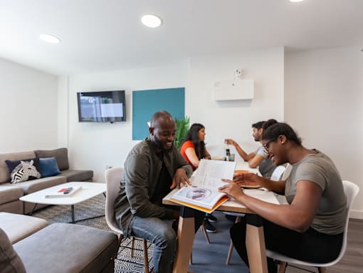 A group of people are gathered around a table in a room.