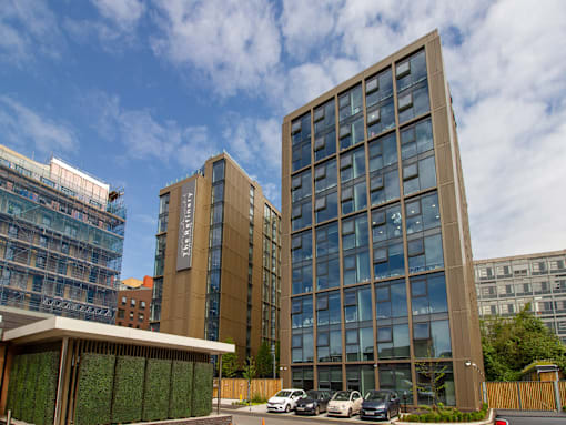 A modern building with a glass facade stands tall in an urban setting.