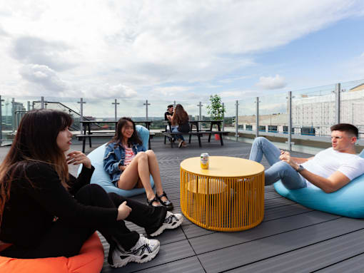 A group of people sitting on bean bags on a rooftop.