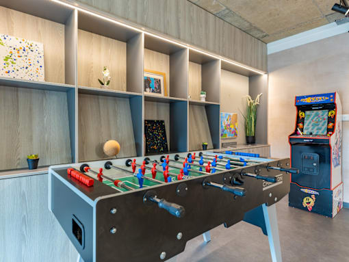 A foosball table is in the middle of a room with a vending machine to the right.