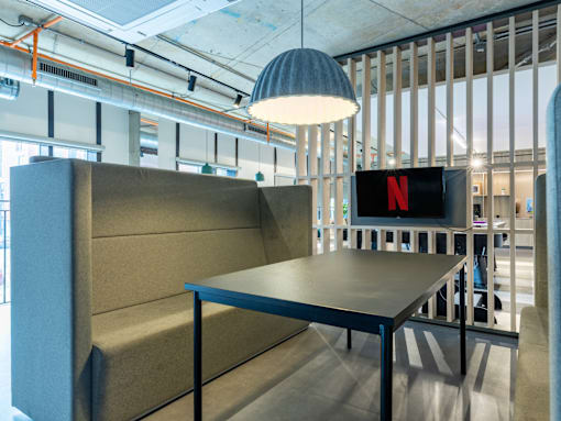 A conference room with a table and chairs and a Netflix sign on the wall.