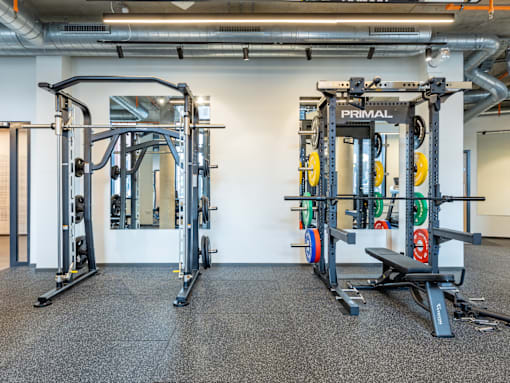 A gym with a black and yellow weight machine.